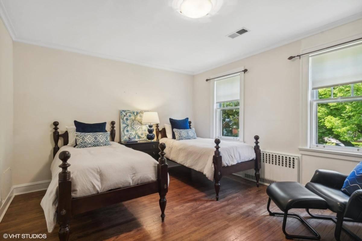 Twin Bedroom with Vintage Wood Beds and Cozy Seating