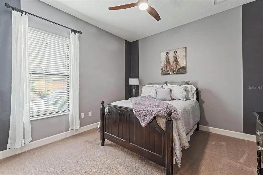 Check Out the Dark Wood Bed Against Soft Gray Tones in This Bedroom