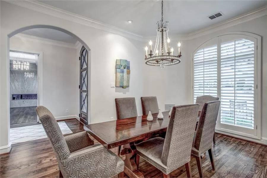 Elegant Dining Room with Eye-Catching Chandelier and Arched Windows