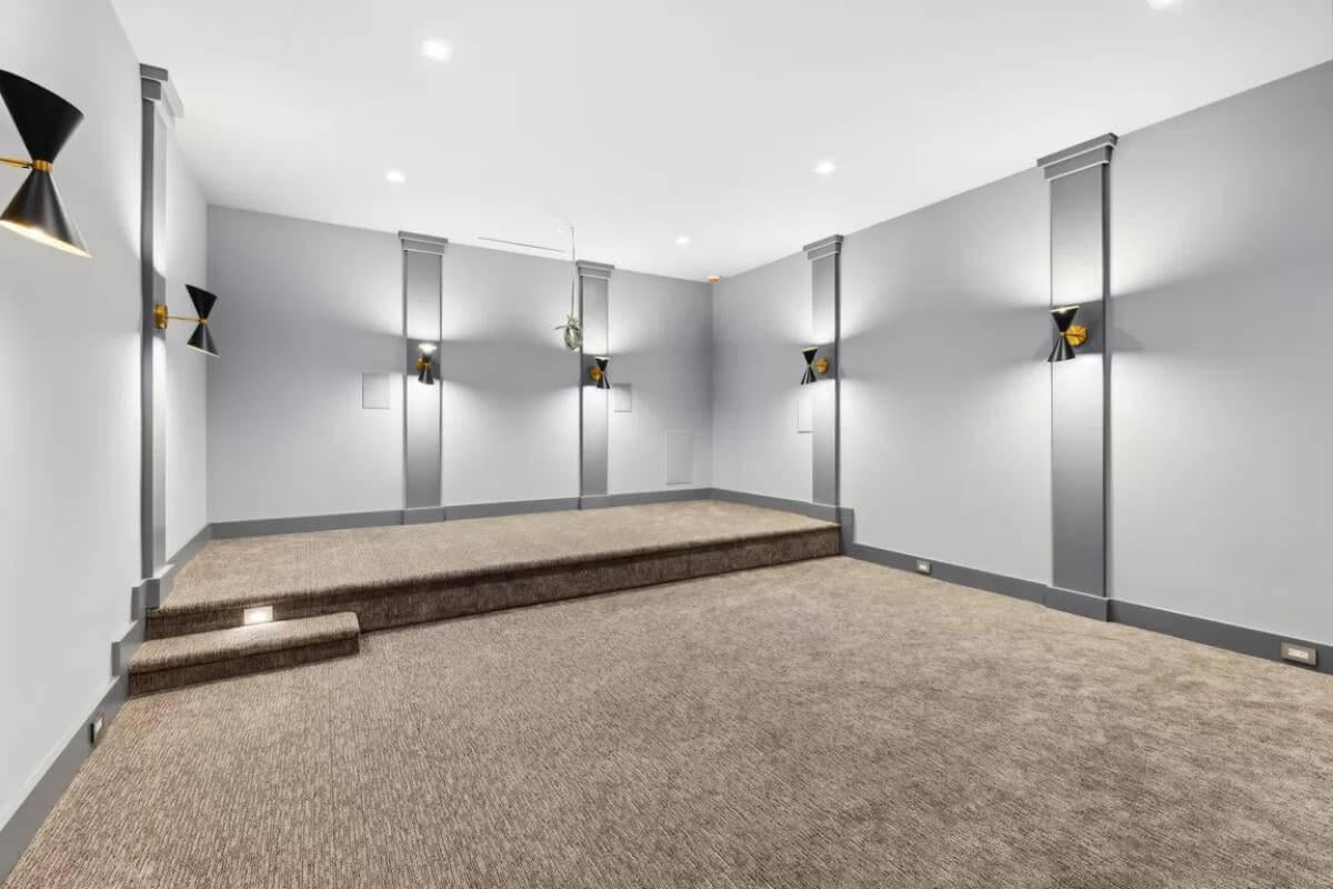 Home Theater with Elevated Platform and Modern Wall Sconces