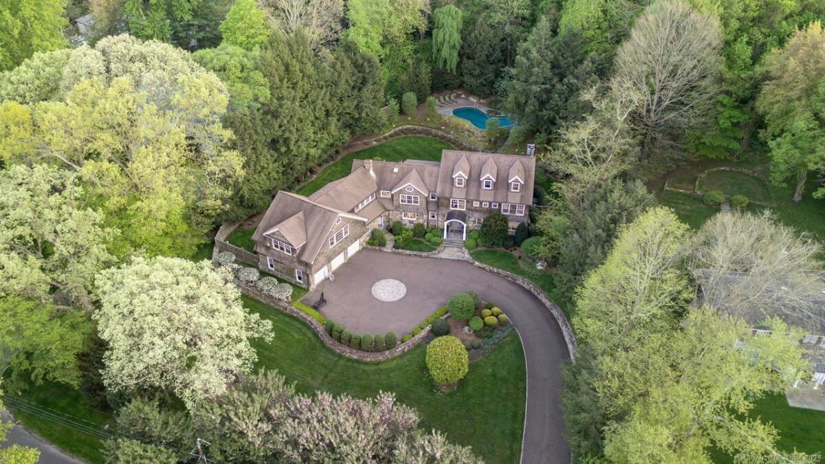 Aerial View of a Grand Craftsman Estate with Curved Driveway and Secluded Pool