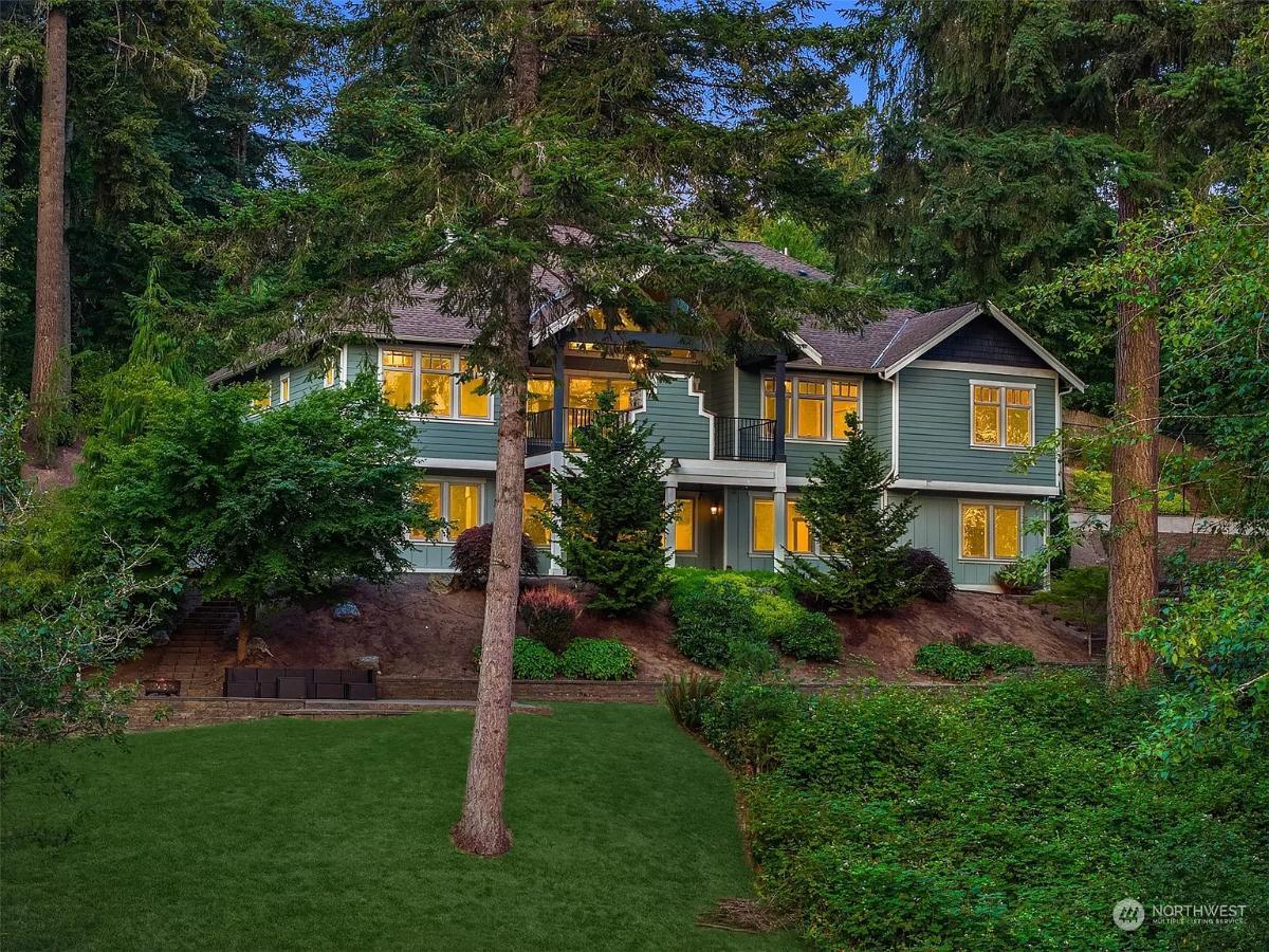 Discover the Warm Glow of Windows Amidst Lush Greenery in This Craftsman Escape
