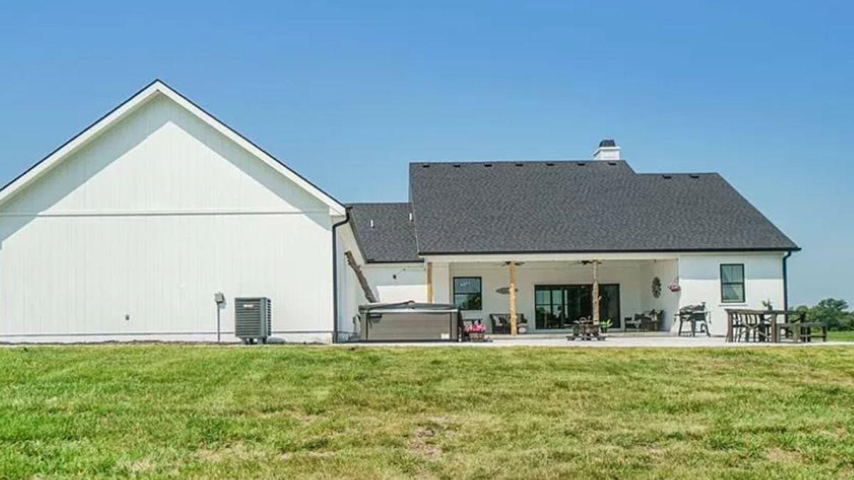 Check Out This Farmhouse Patio with a Hot Tub and Dining Area