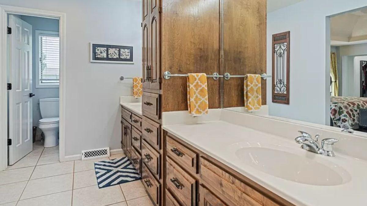 Notice the Warmth of the Wooden Cabinetry in This Bathroom Layout