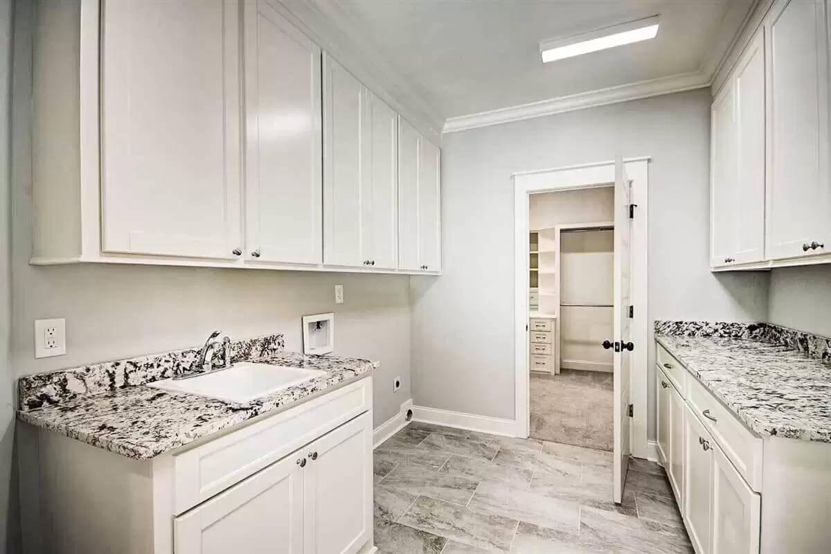 Laundry Room Elegance with Granite Counters and Ample Cabinetry
