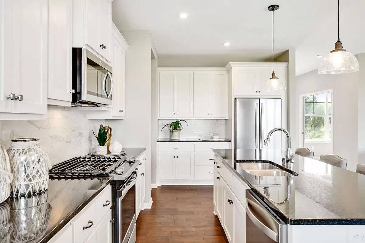 Sleek Kitchen with a Stylish Black Granite Island and Glass Pendant Lighting