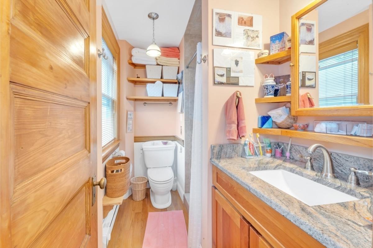 Charming Bathroom with Open Shelving and Granite Counter