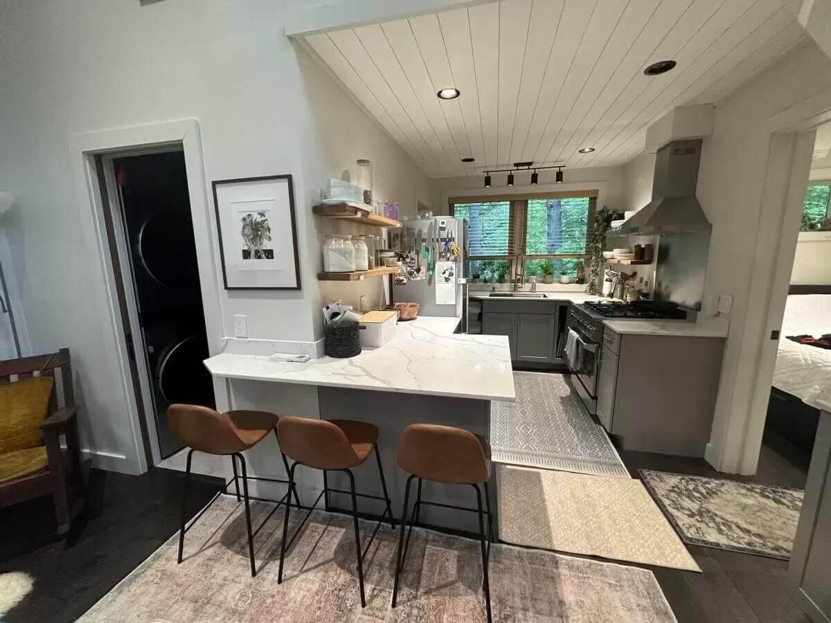 Explore the Cozy Breakfast Bar and Open Shelving in This Compact Kitchen