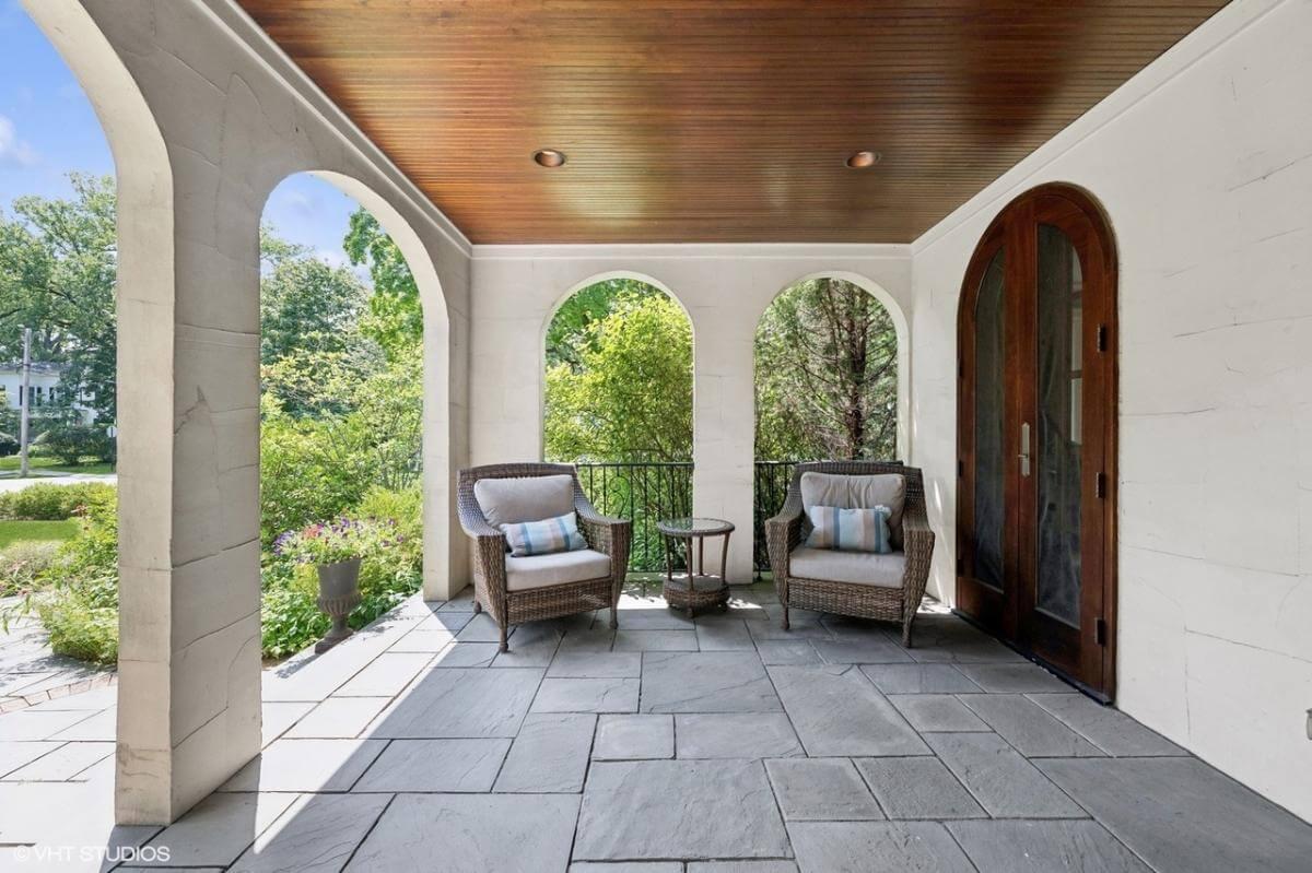 Charming Porch with Arched Openings and Cozy Wicker Seating