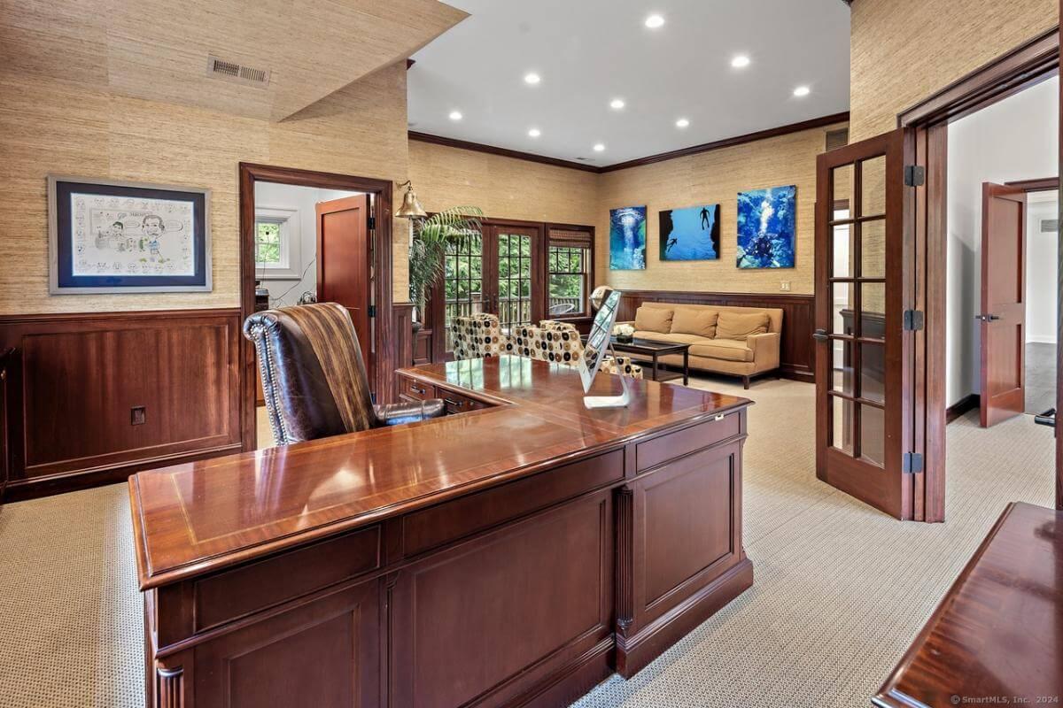 Spacious Home Office with Rich Wood Paneling and Cozy Seating Area