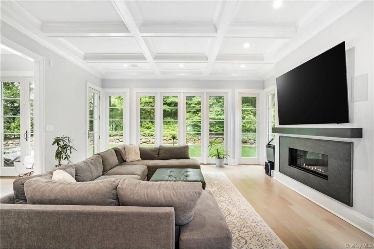 Relax in This Family Room with Coffered Ceiling and a Modern Fireplace