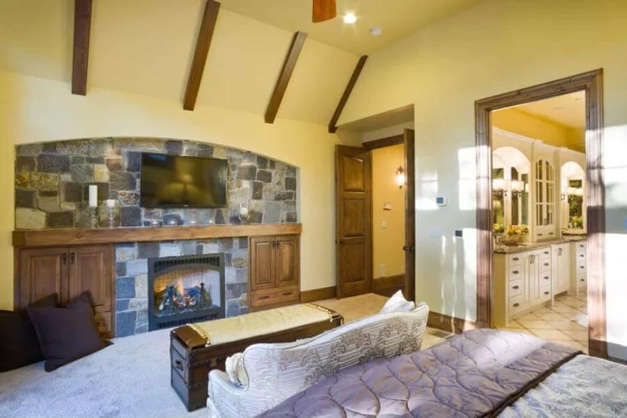Cozy Bedroom with Stone Fireplace and Vaulted Beams