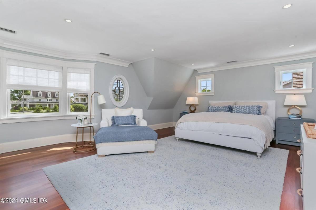 Tranquil Bedroom with Unique Oval Window and Cozy Reading Nook