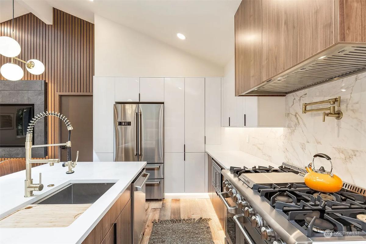 Admire the Sleek Brass Details Against the Marble Backsplash
