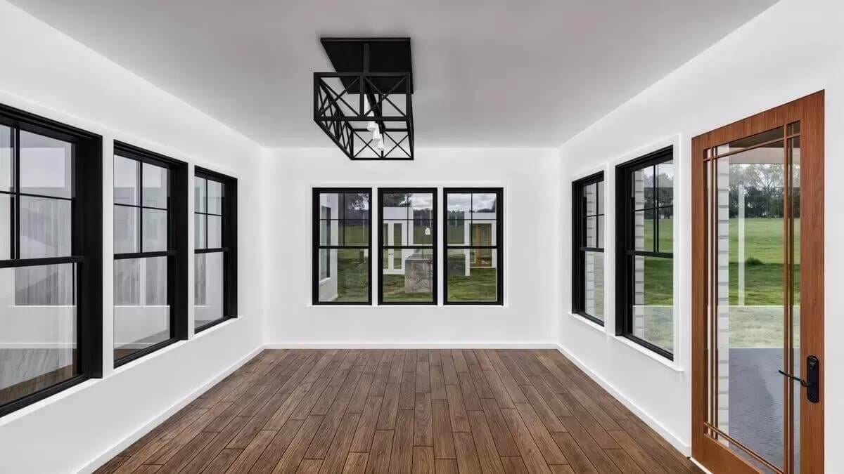Sunroom with Black-Framed Windows and Modern Lighting