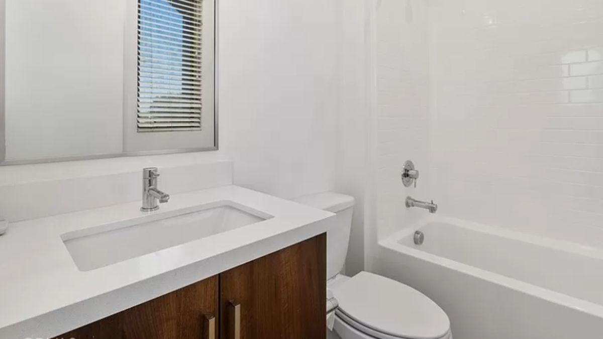 Compact Bathroom Featuring Warm Wood and Sleek Fixtures