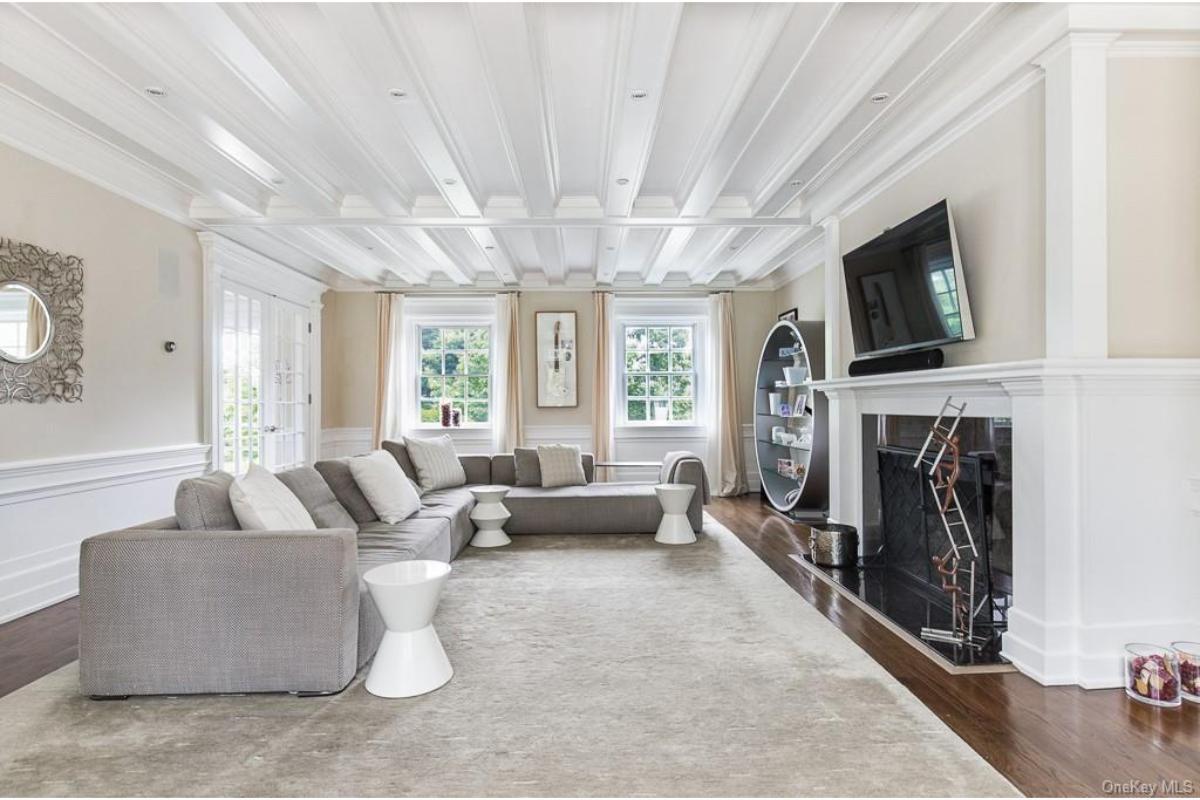 Spacious Living Room with Striking Tray Ceiling and Bold Geometric Shelving
