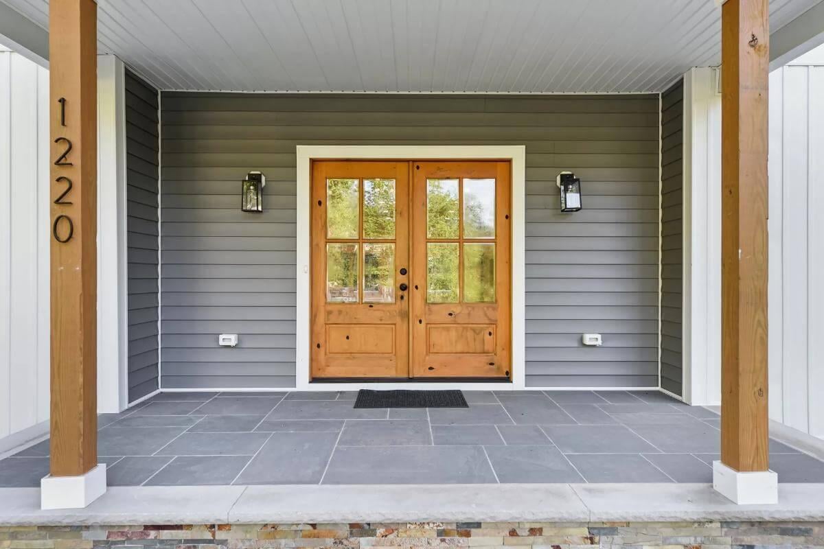 Welcoming Entryway with Double French Doors and Sleek Stone Flooring