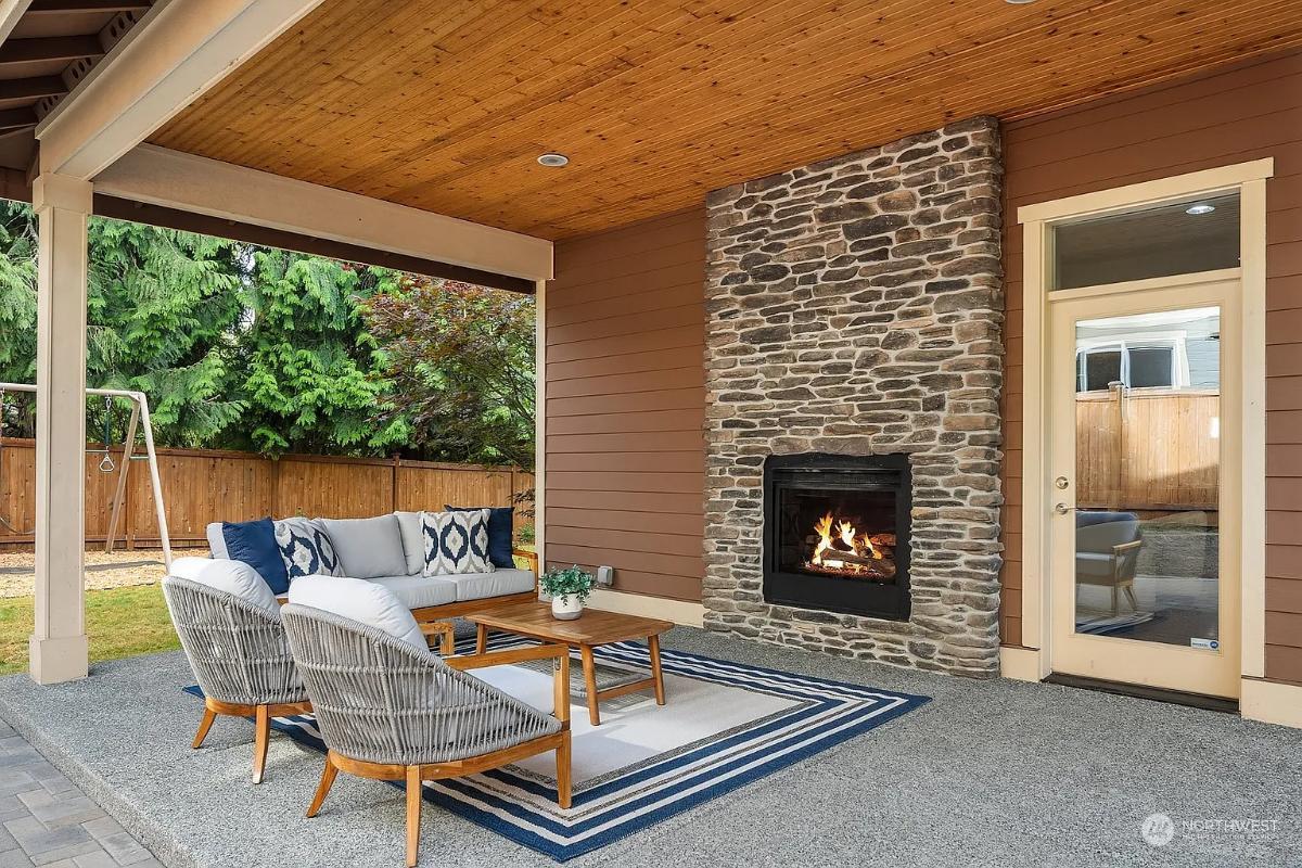 Outdoor Living Area with Stone Fireplace and Woven Seating