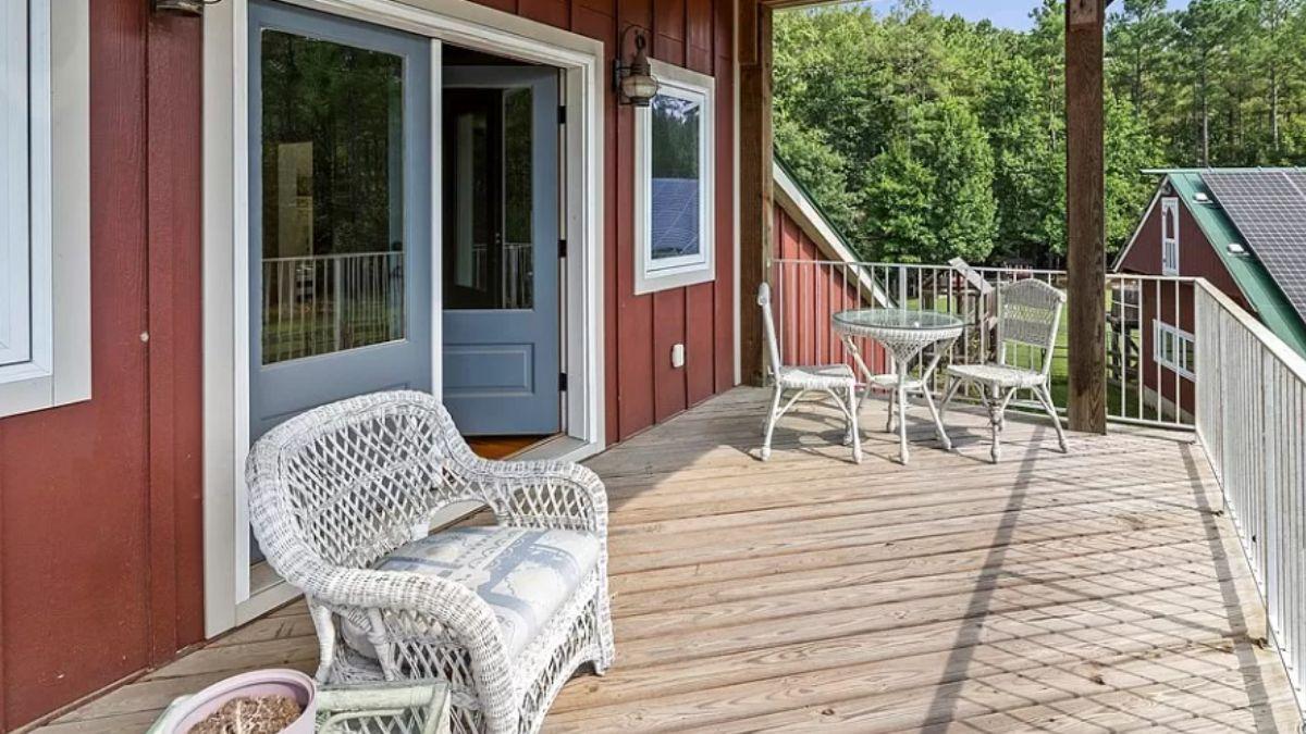 Take In the Red Facade and Cozy Wicker Seating on This Inviting Deck