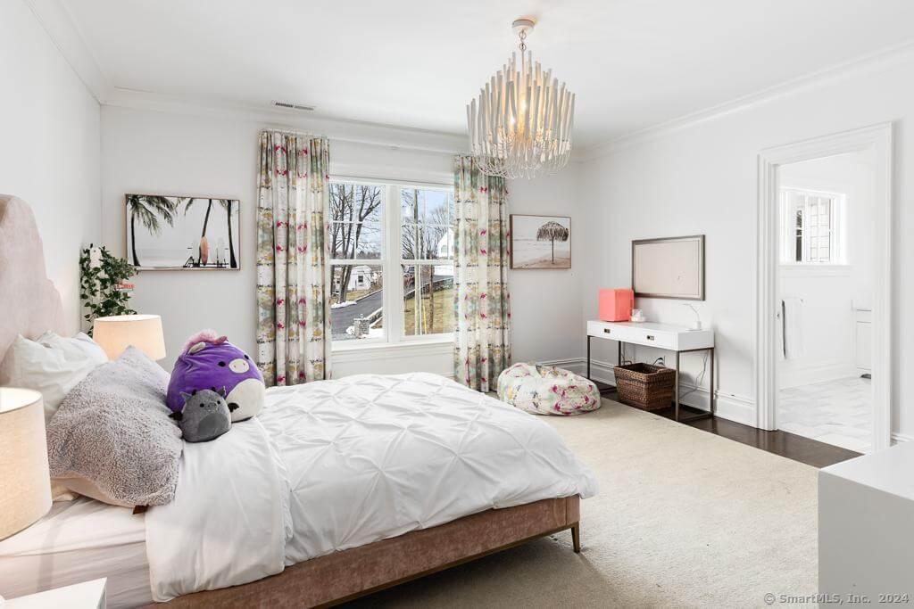 Charming Bedroom with a Statement Chandelier and Floral Touches