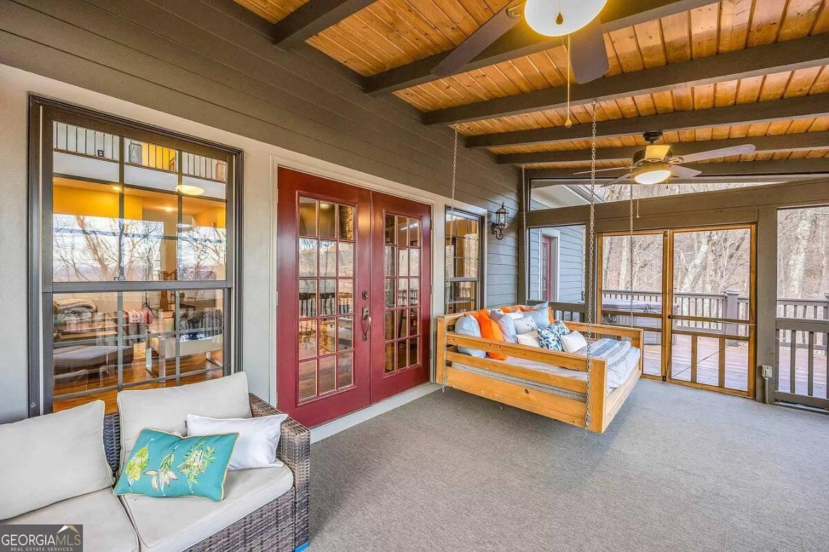 Experience Tranquility on This Screened Porch with a Cozy Swing Bed