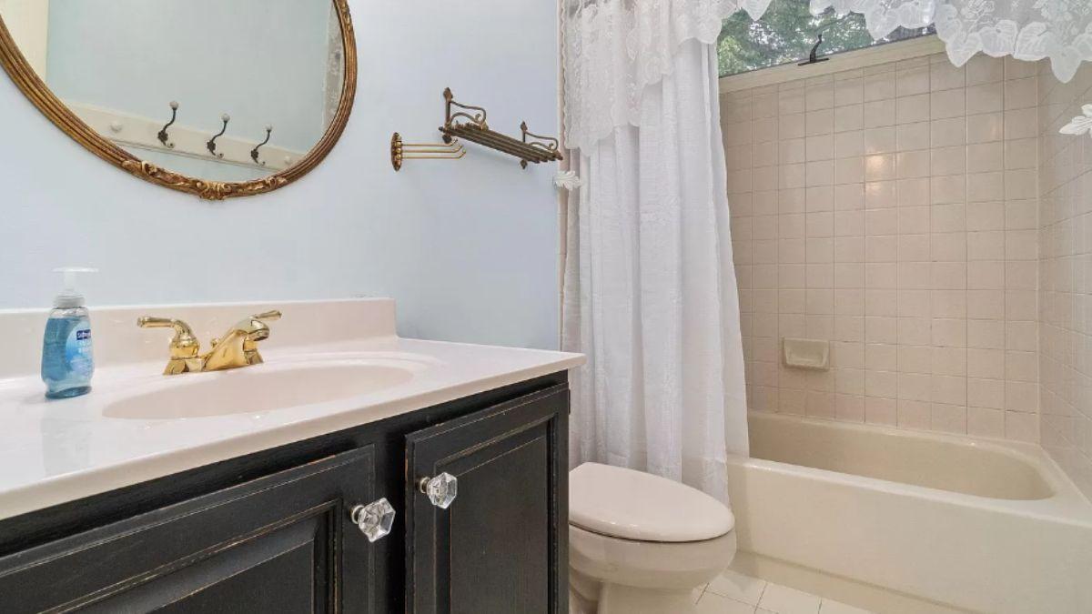 Notice the Vintage Charm with Brass Accents in This Bathroom Retreat