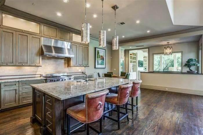 Gourmet Kitchen with a Standout Granite Island and Leather Bar Stools