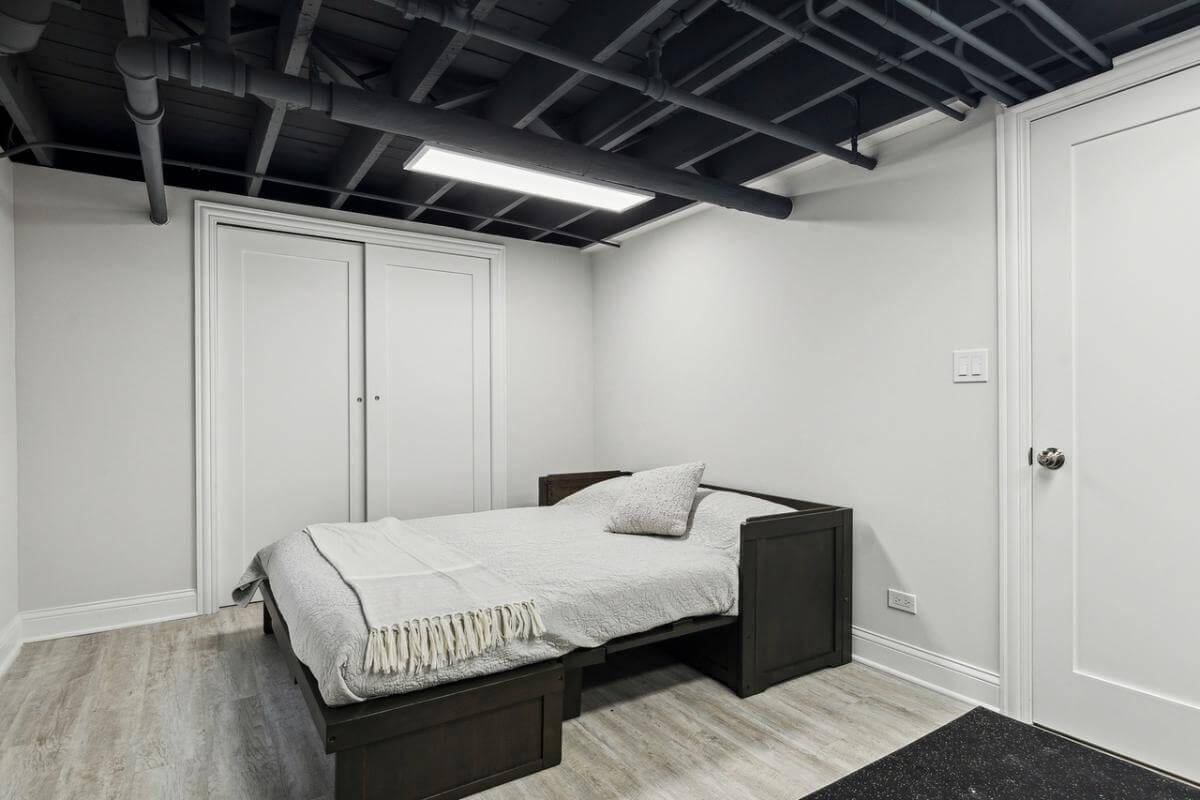 Notice the Industrial Touch in This Sleek Basement Bedroom