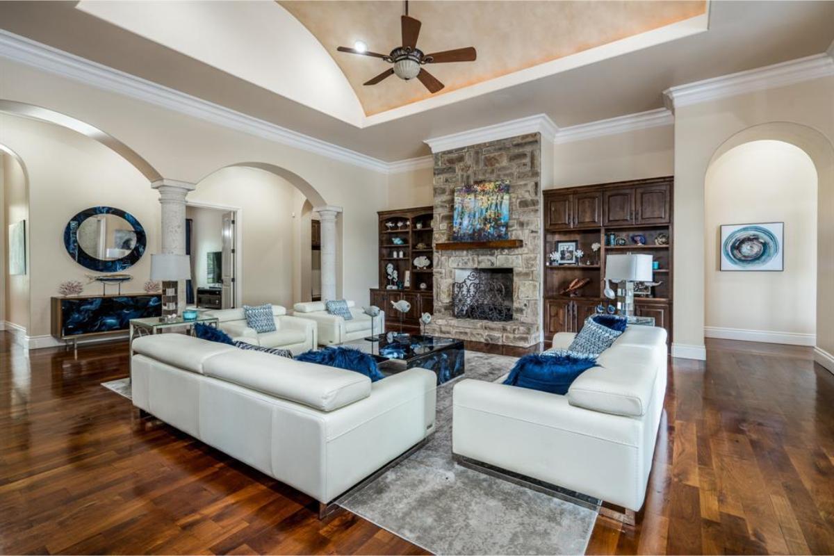 Vaulted Living Room Featuring a Stone Fireplace and Elegant Ceiling Design