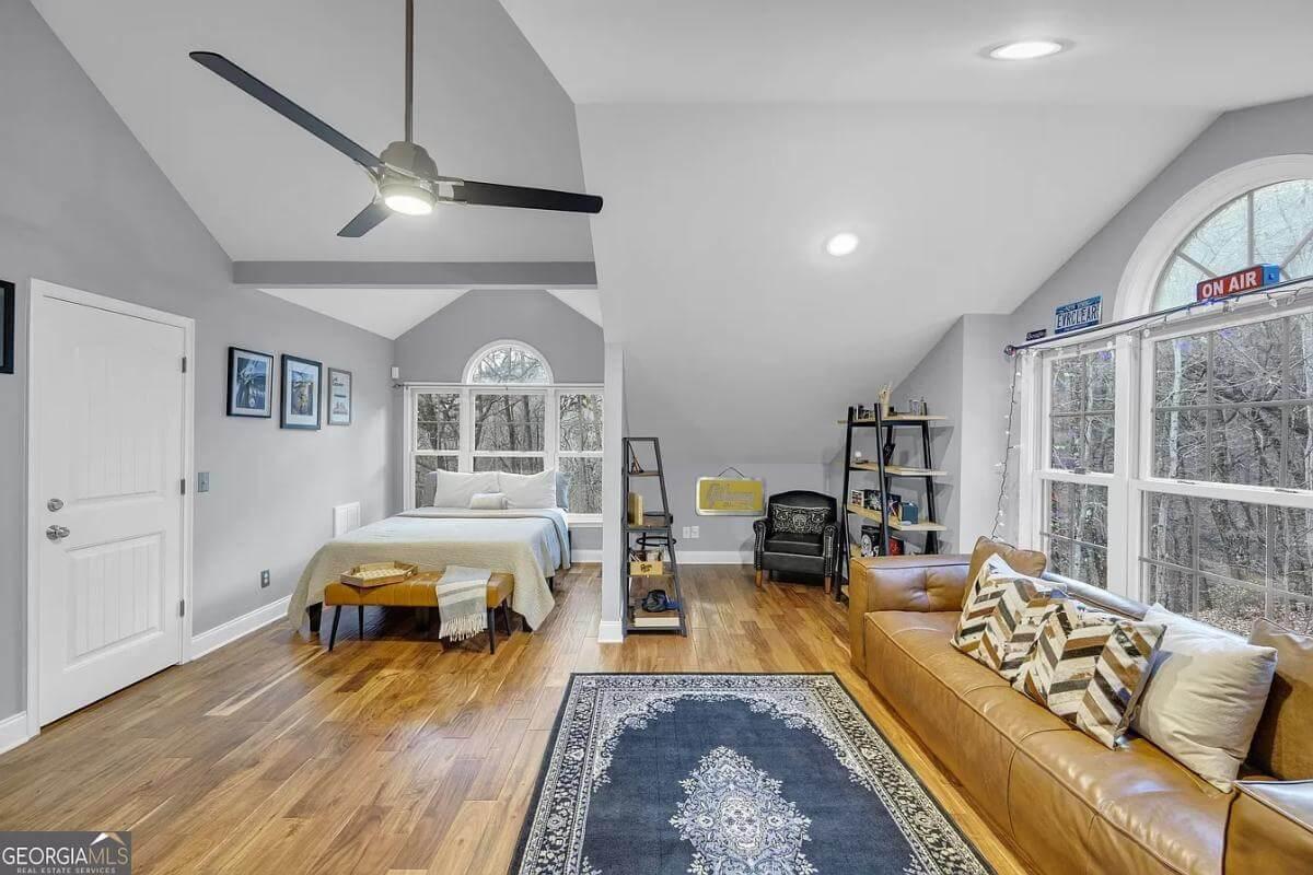Loft-Style Bedroom with Arched Windows and Cozy Nook