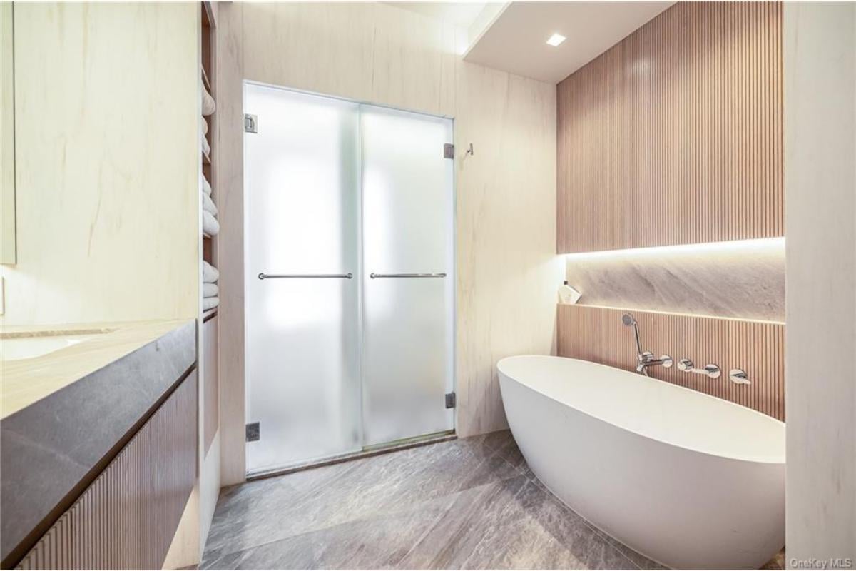 Soak It Up in This Modern Bathtub with Wood Panel Accents