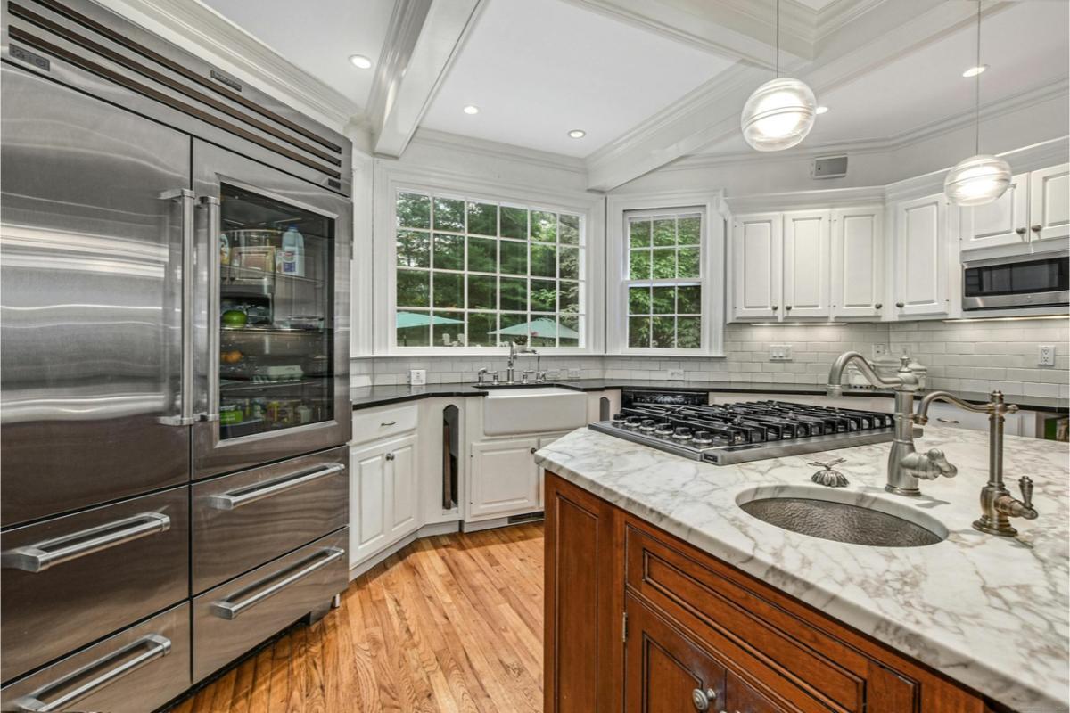 Classic Kitchen with a Marble Island and Farmhouse Sink