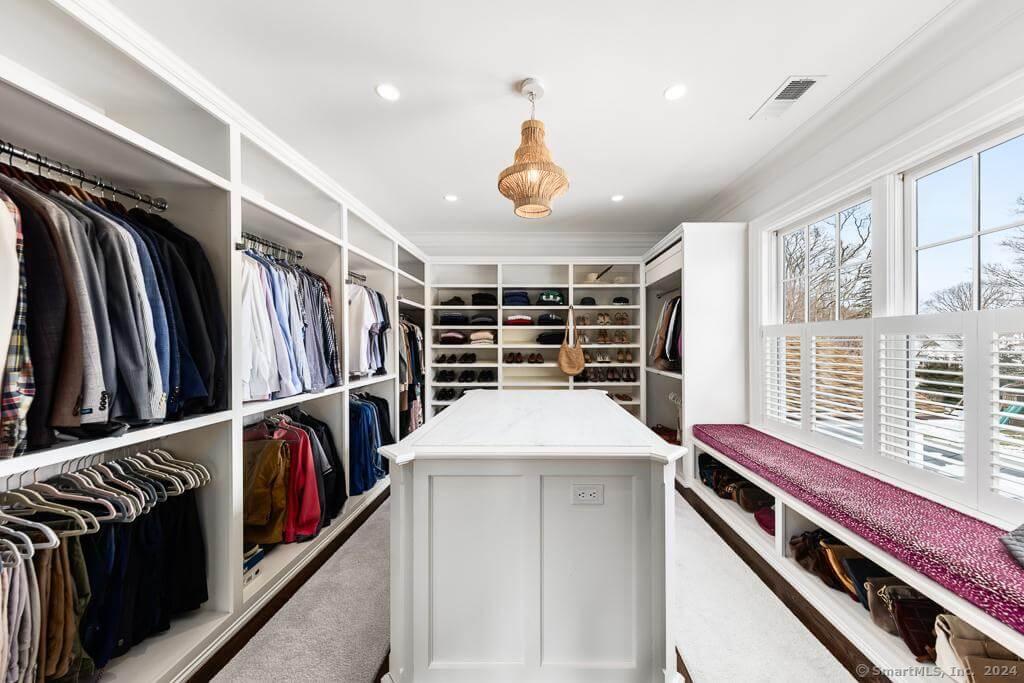 Explore This Walk-In Closet with a Functional Island and Cozy Window Seat