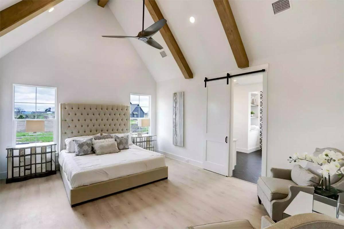 Embrace the Vaulted Ceilings and Barn Door Charm in This Serene Bedroom