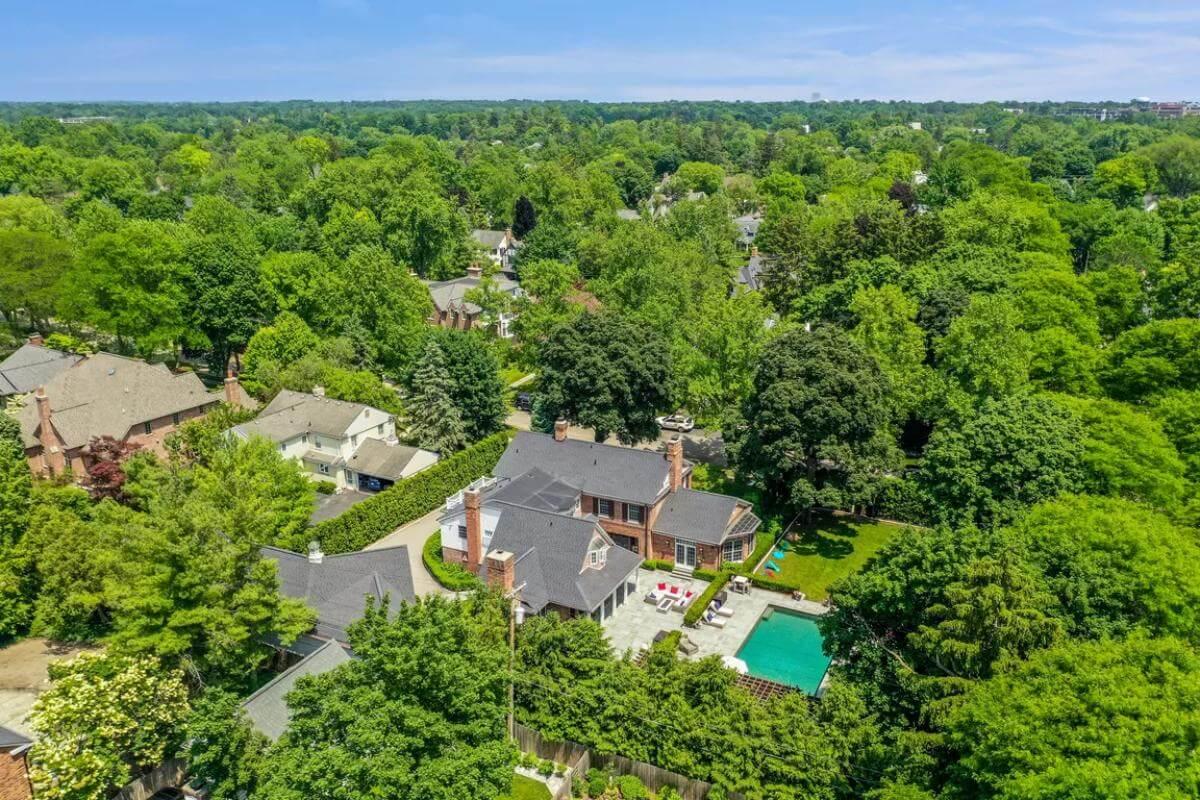Aerial View of Brick Estate with Lush Greenery and Refreshing Pool