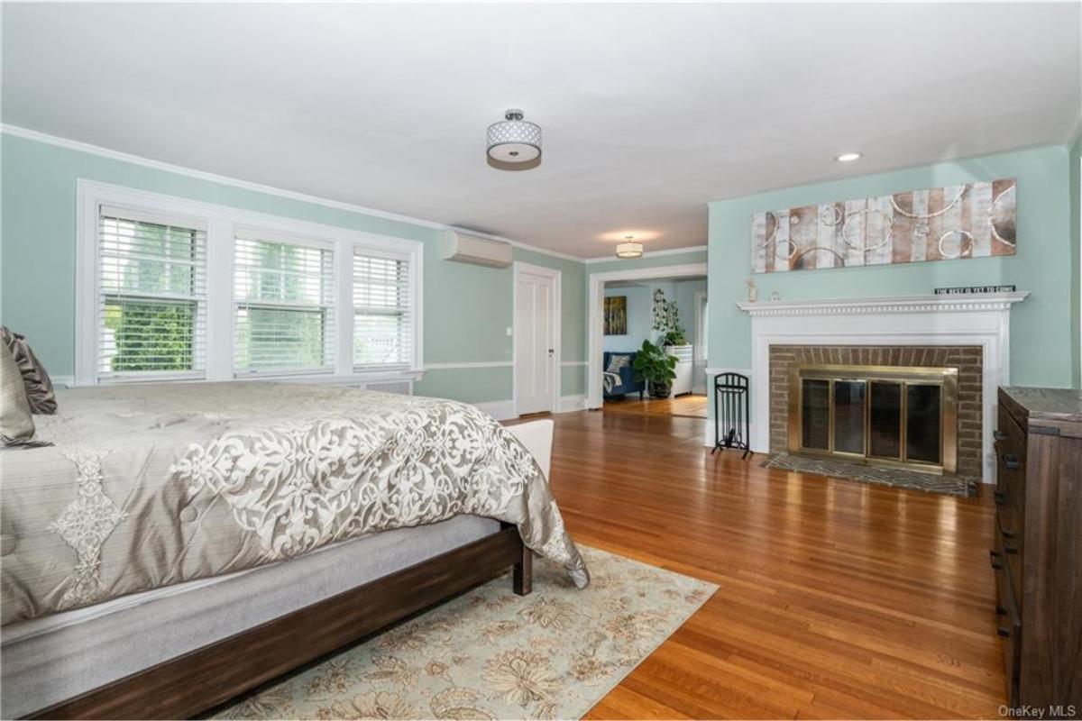 Relax in the Calming Bedroom Featuring Mint Walls and a Brick Fireplace