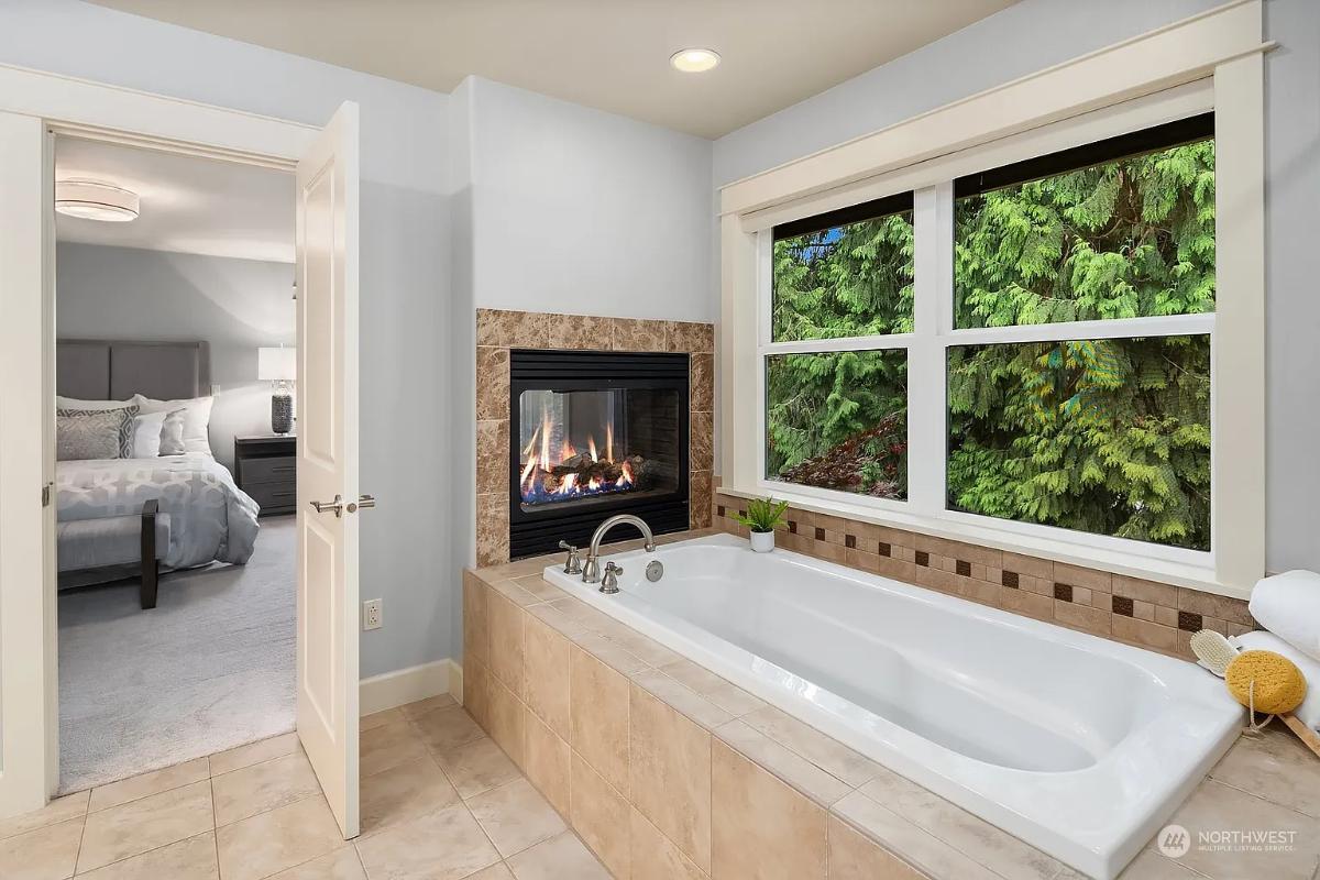 Relaxing Bathroom with Forest Views and a Double-Sided Fireplace
