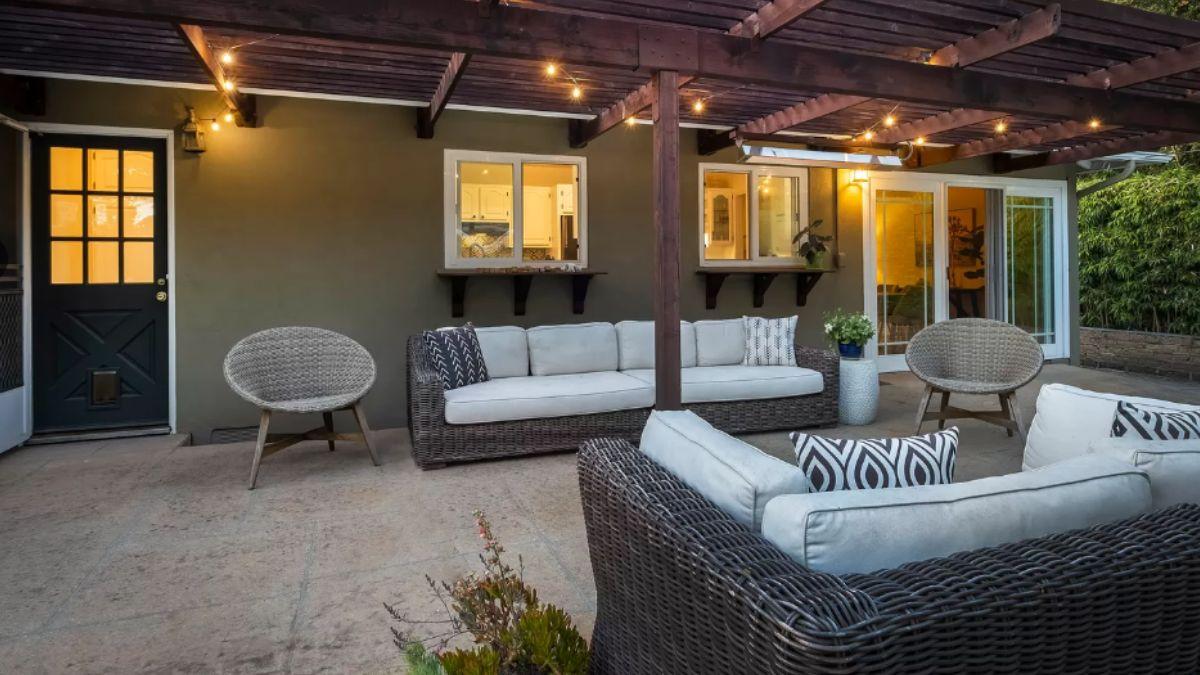 This Patio Features a Cozy Setup Under a Wooden Pergola
