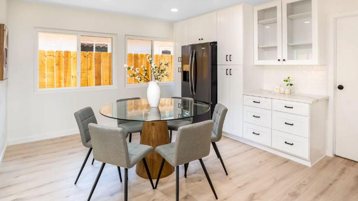 Chic Breakfast Nook with Glass Table and Sleek Cabinetry
