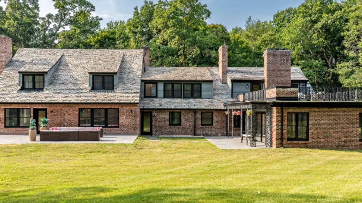 Timeless Brick Facade with Expansive Patio and Lush Backdrop