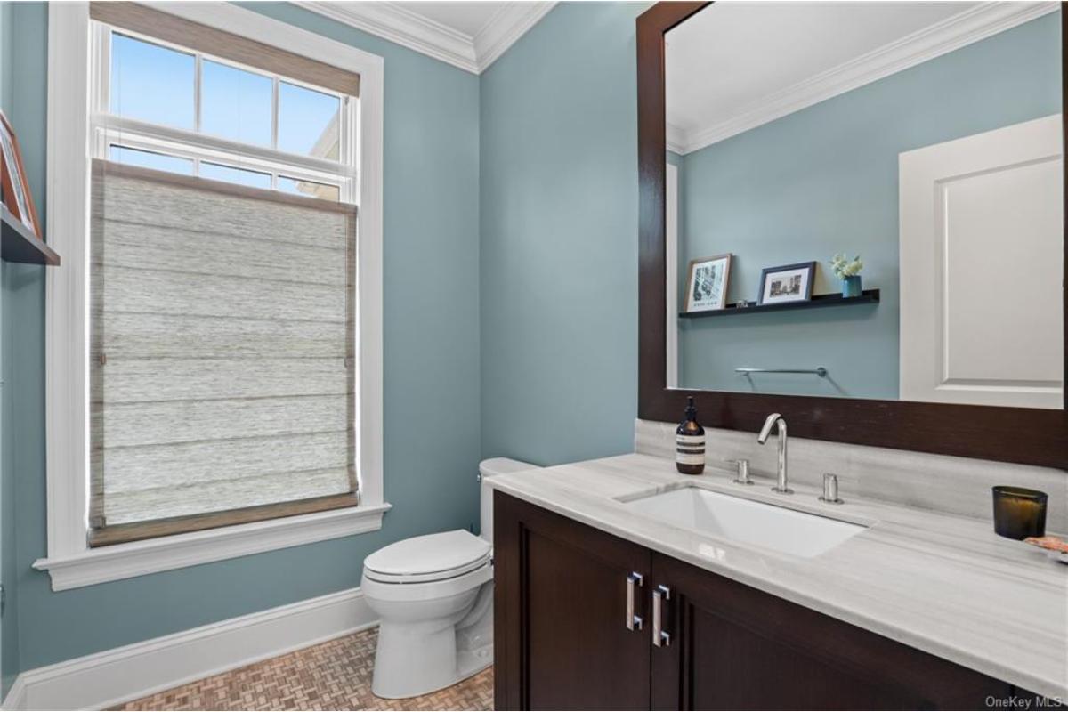 Powder Room with Elegant Trim and a Big Mirror Reflecting Style