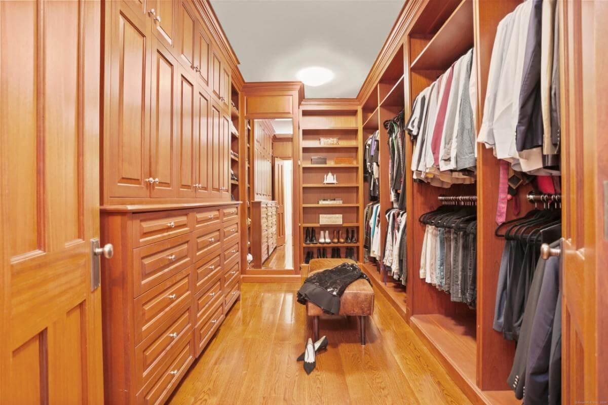 Step Inside the Luxurious Walk-In Closet with Rich Wooden Finishes