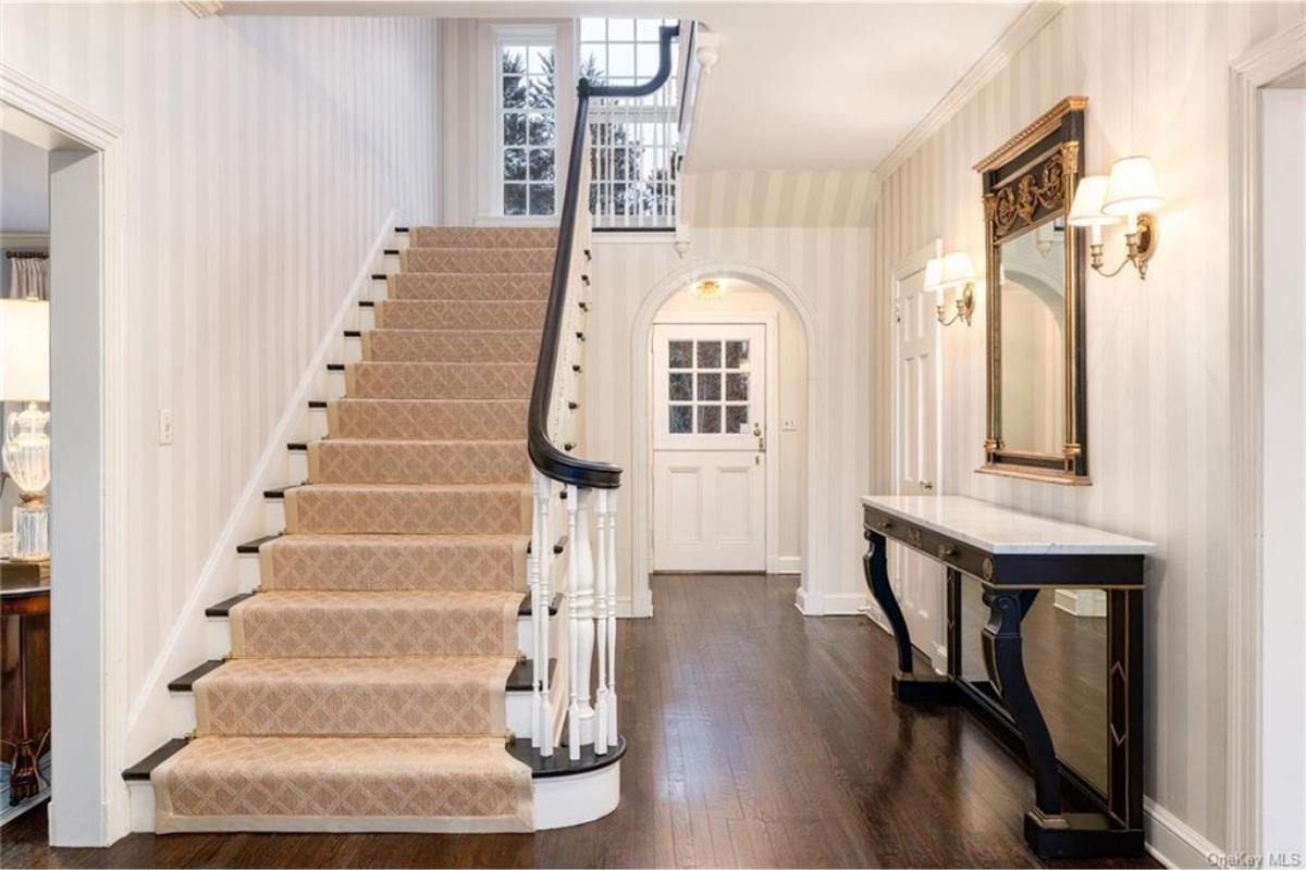 Grand Entryway with Elegant Staircase and Striped Walls
