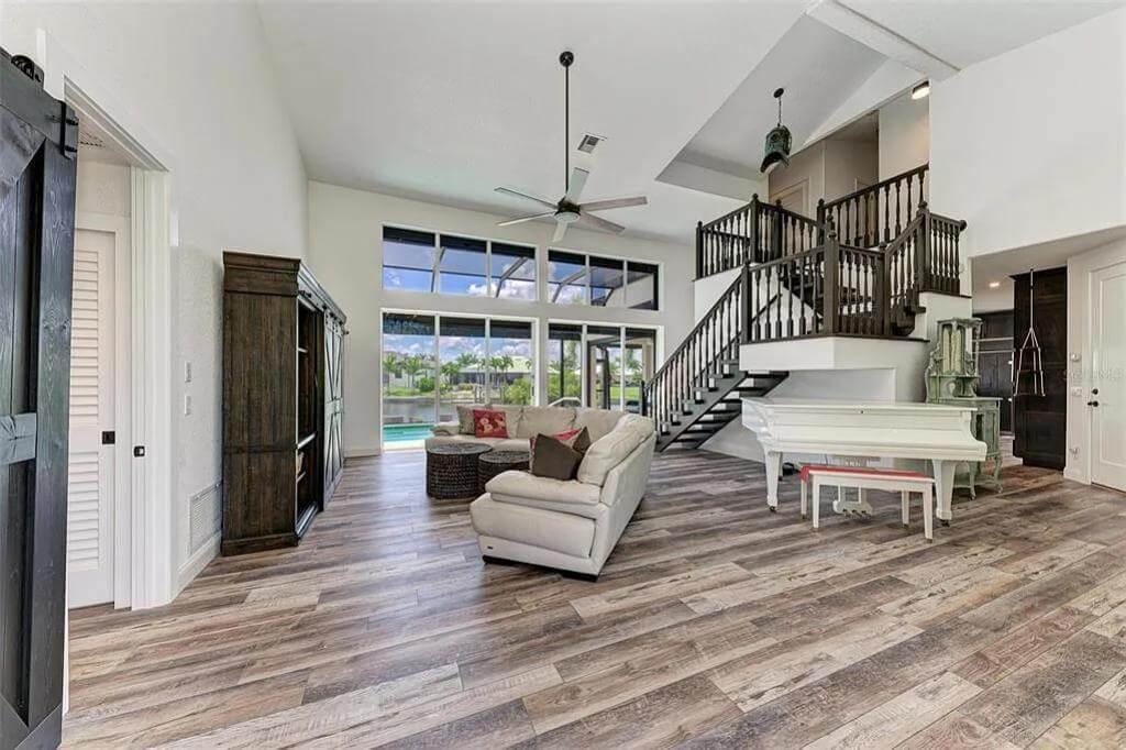 Open Living Room with Rustic Floors and Striking Staircase