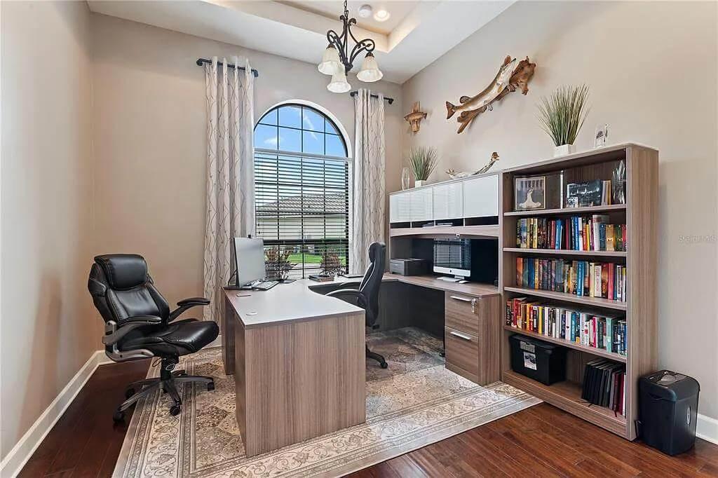 Efficient Home Office with Arched Window and Bookcase Wall
