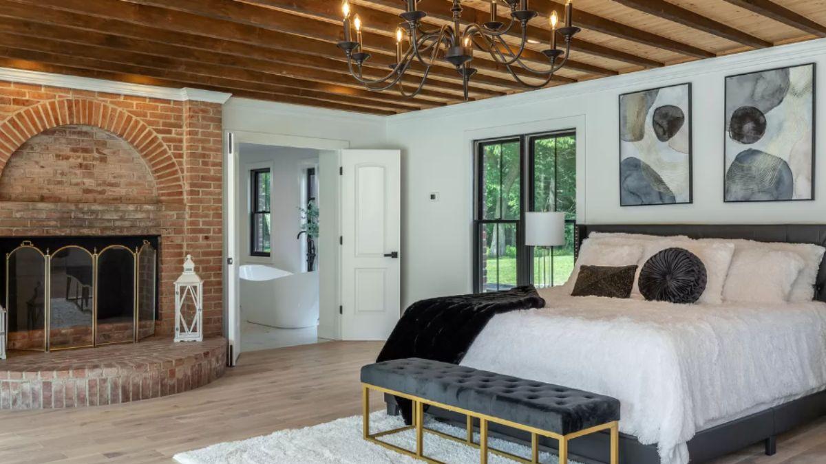 Check Out the Exposed Beam Ceiling and Brick Fireplace in This Inviting Bedroom