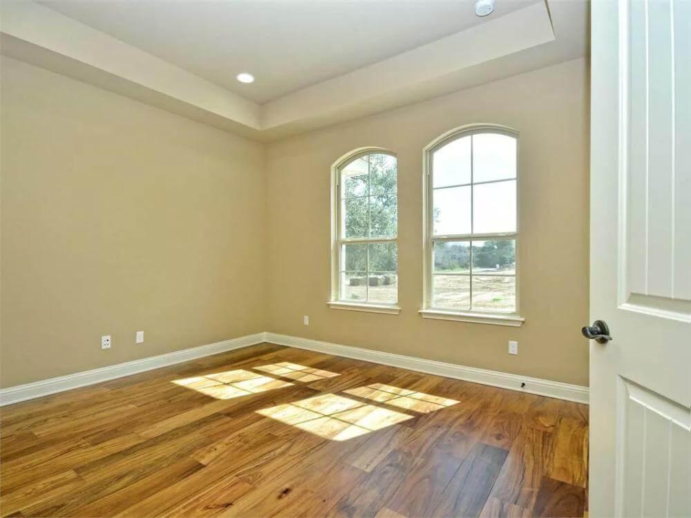 Sunlit Room with Arched Windows and Warm Wood Floors