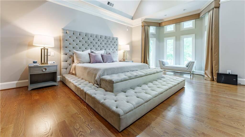 Explore the Spacious Bedroom with Plush Tufted Bed and Bay Windows