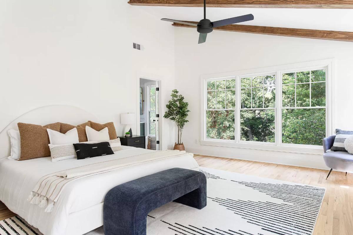 Charming Bedroom Retreat with Exposed Wood Beams and Large Windows